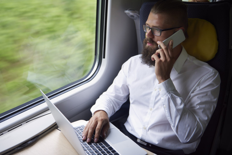 man in trein met laptop