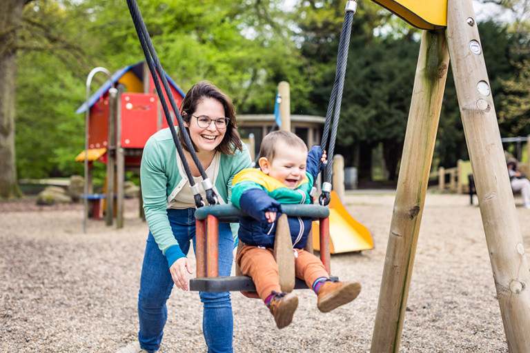 Mama duwt baby op schommel