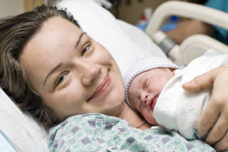 Une maman qui vient d'accoucher dans son lit d'hôpital