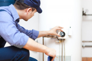 Technicien avec casquette répare boiler