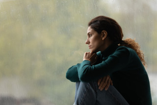 Femme pensive qui regarde par la fenêtre