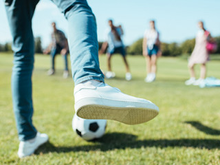 Voet met voetbal gaat trappen naar tieners op een rij