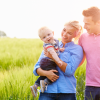 Ouders met kind in de hand op een grasveld.